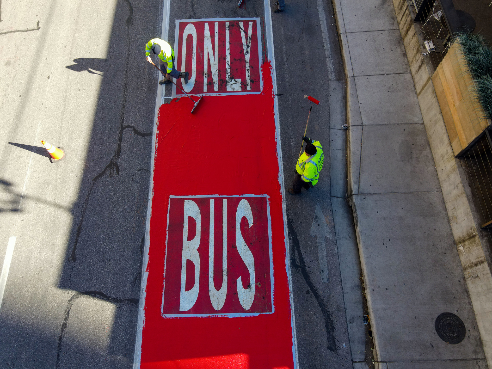 Workers paint a bus only lane red